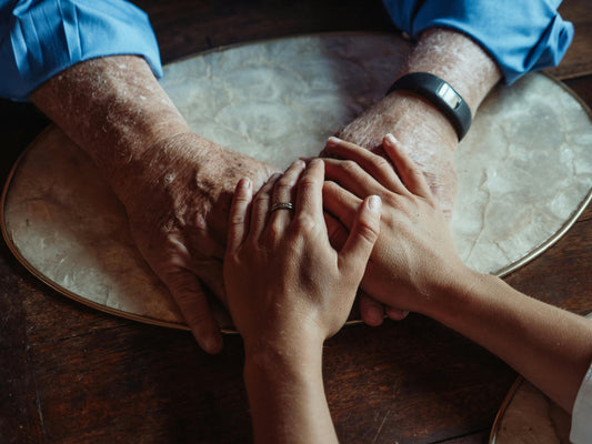 Young hands ontop of older hands representing the exchange of wisdom